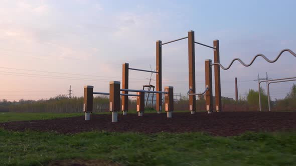 A Camera Passes By a Outdoor Gym During a Sunrise. Footage From Left To Right alt