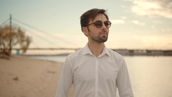 Man Walking On City Beach. Close Up  Cheerful Guy Walks On Sand And Leaves Footprints. alt