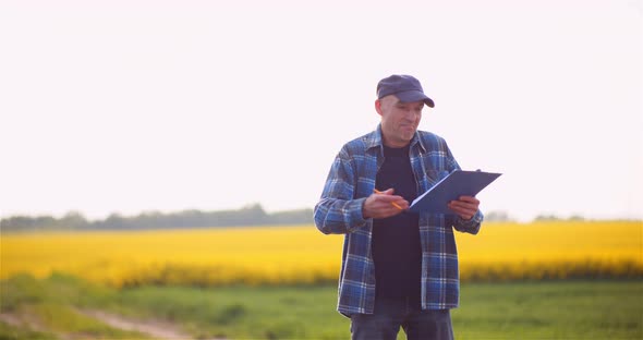 Farmer Talking on Mobile Phone While Working in a Field Agriculture alt
