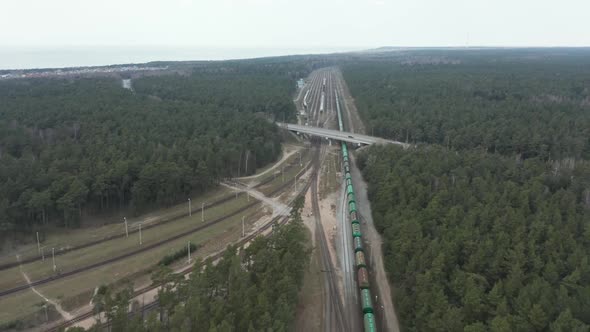 AERIAL: Long Transportation Cargo Train Driving on a Railroad in Klaipeda