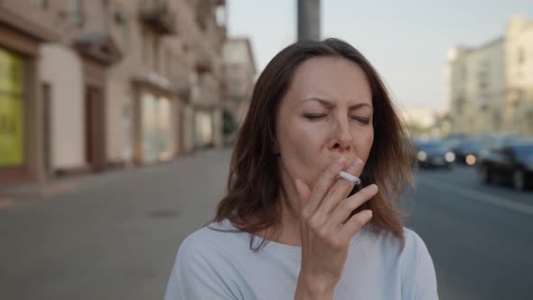Portrait of a Brunette on a City Street Against the Background of Passing Cars is Out of Focus alt