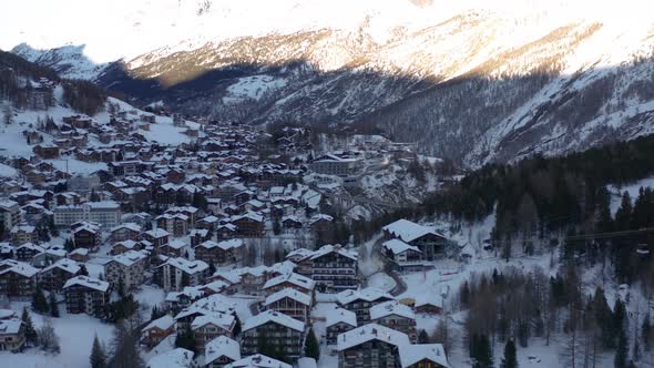 Aerial of idyllic winter town in the Swiss mountains alt