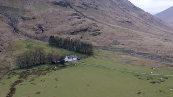 The Glencoe Valley and a Small House Surrounded by Mountains in the Highlands alt