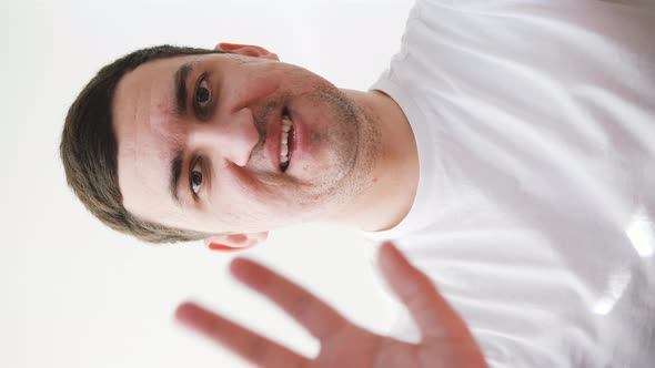 Young Man in White Tshirt Saying Hello During a Video Call on Phone alt