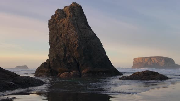 Calm ocean seascape at Bandon Beach with table rock in the background. No people, only beautiful lan alt
