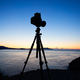 Photo camera silhouette on tripod at rocky beach - PhotoDune Item for Sale