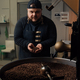 Man smelling coffee beans from cooling tray - PhotoDune Item for Sale