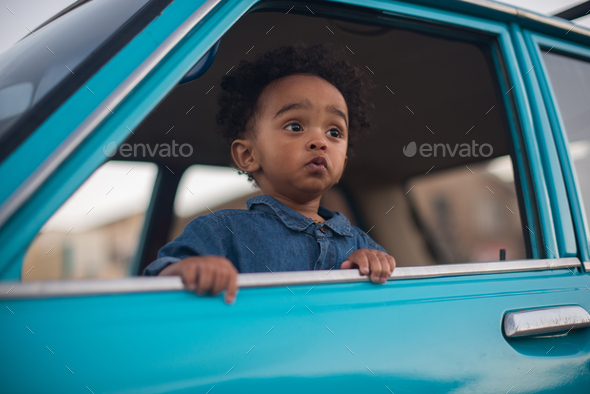 Portrait of handsome young boy leaning out of vehicle - Stock Photo - Images