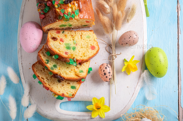 Delicious Fruitcake for Easter surrounded by eggs and spring flowers. - Stock Photo - Images