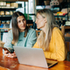 Two businesswomen colleagues are discussing a project while sitting in a cafe. - PhotoDune Item for Sale