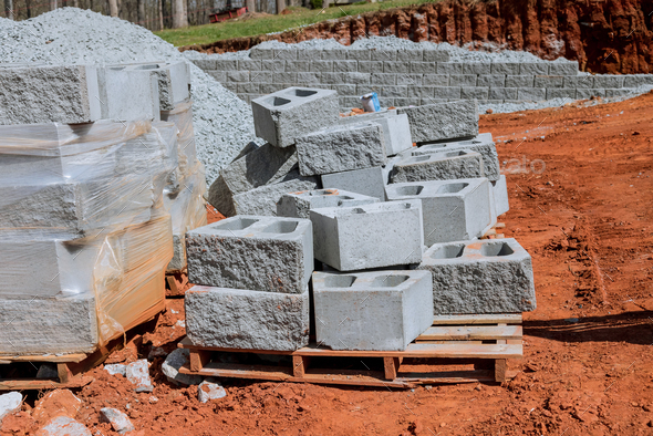 On a newly constructed home, there is retaining wall being built on property adjacent to it - Stock Photo - Images