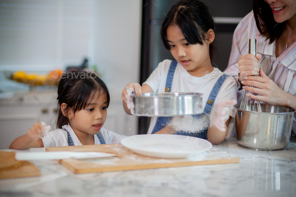 Two little cute Asian girls, learning how to make bread and bakery with ...