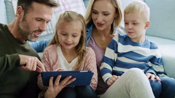 Happy family using technology in living room alt