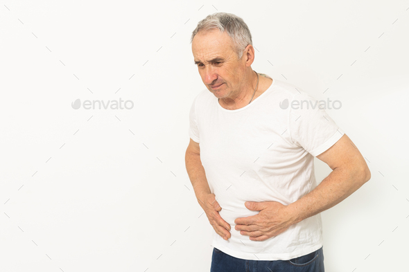 Elderly men have abdominal pain sitting on the sofa in the house. Concept Problems of the digestive