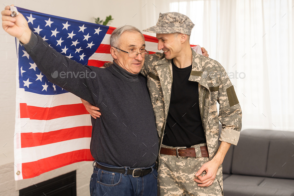 an elderly father and a military son saluting American flag