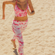 athletic woman in sportswear runs along sandy beach. sporty lady prepares for marathon - PhotoDune Item for Sale