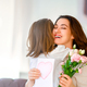 Daughter giving mother bouquet of flowers. - PhotoDune Item for Sale