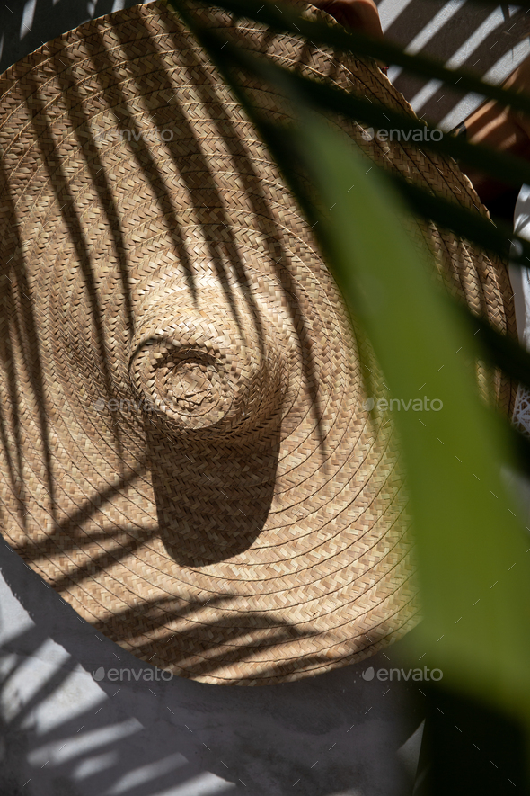Beauty shadows of palm leaves on beach straw hat - Stock Photo - Images