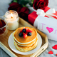 Mother&#39;s Day concept. Pancakes with berry, tea cup, burning candle, flowers and gift box. - PhotoDune Item for Sale