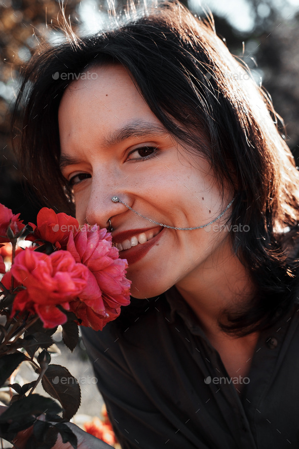 Close up portrait of beautiful smiling young woman with nose piercing decorated with metal chain. - Stock Photo - Images