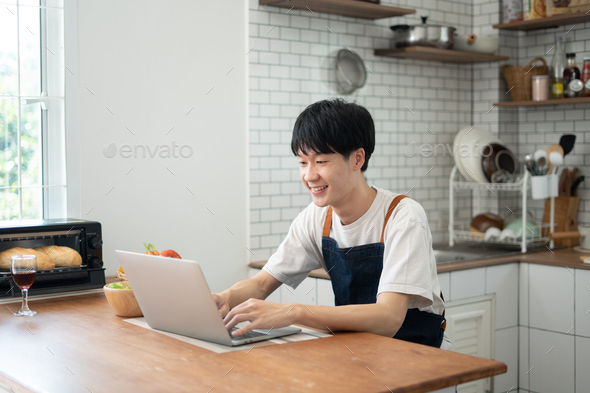 Young man learning to cook while watching tutorials in internet. - Stock Photo - Images