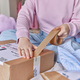 Cropped shot of unrecognizable woman prepares parcel for client at home packs paper box with skotch - PhotoDune Item for Sale