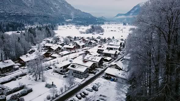 Aerial sliding view of Grainau town in a snowy winter. Roofs covered by snow. Bavaria, Germany. alt
