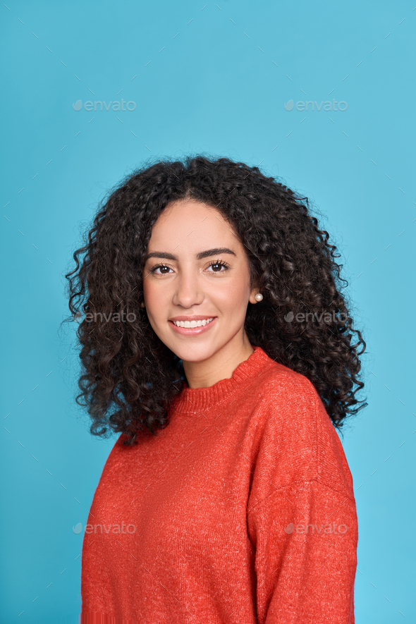 Young smiling latin woman standing isolated on blue background, portrait. - Stock Photo - Images