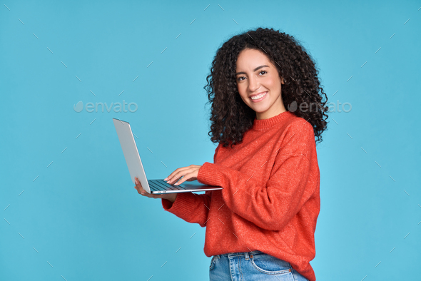 Young happy latin woman using laptop isolated on blue background. - Stock Photo - Images