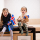 Two sisters are sitting on a couch at home with icelandic flags on hands. - PhotoDune Item for Sale