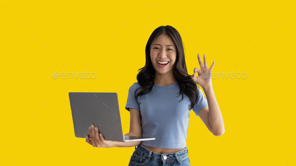 Asian woman in casual clothes holding working laptop in freelance work concept - Stock Photo - Images