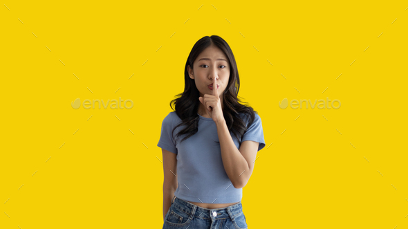 Asian woman doing silent gesture with finger - Stock Photo - Images