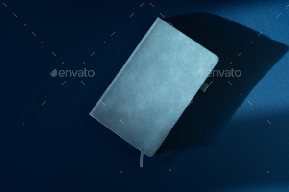 Simple blue diary on a colored background, top view - Stock Photo - Images