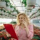 Young woman working in a greenhouse and using a smartphone - PhotoDune Item for Sale