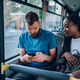 Multiracial friends talking and using a smartphone while riding a bus in the city - PhotoDune Item for Sale