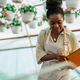 African american woman working in a greenhouse and holding clipboard - PhotoDune Item for Sale
