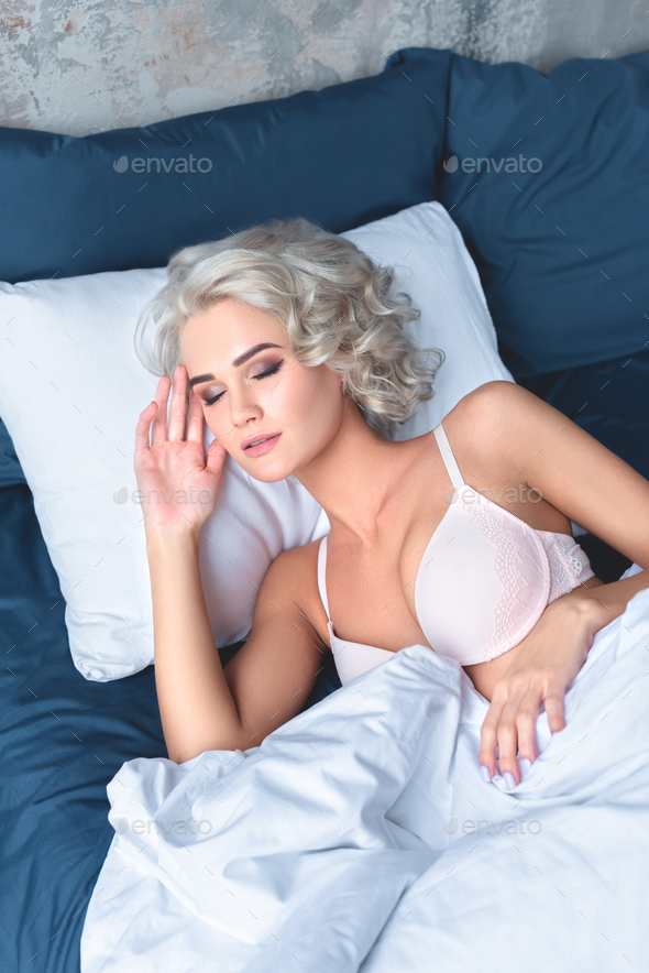attractive young woman with curly hair sleeping in underwear Stock