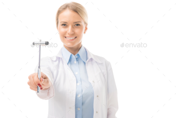 smiling young female neurologist holding reflex hammer and looking at camera isolated on white
