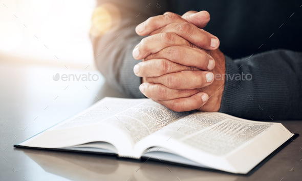 Bible, hands and prayer of a man reading christian text for spiritual healing and religion. Lens fl