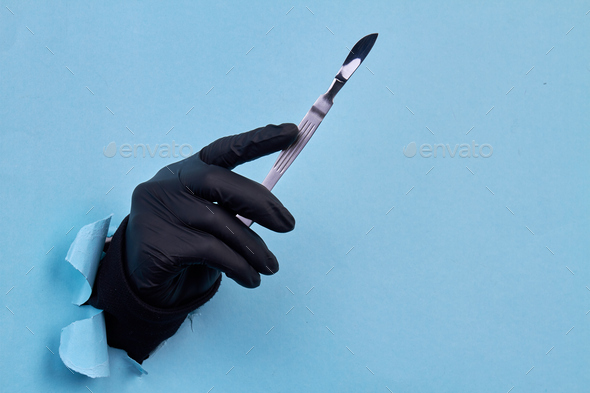 Close up hand in black glove holding scalpel. - Stock Photo - Images