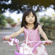Happy Asian child girl ride a bike at the park outdoor. - PhotoDune Item for Sale