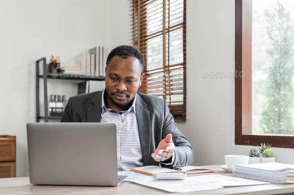 Stressed business man sitting at office workplace. Tired and overworked black man. Young african - Stock Photo - Images