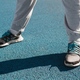 Close-up of woman&#39;s legs in sneakers standing on rubber surface of an outdoor sports field - PhotoDune Item for Sale