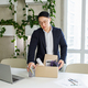 Firing and job loss concept. An Asian man is fired from job and is packing things into cardboard box - PhotoDune Item for Sale