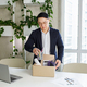 Firing and job loss concept. An Asian man is fired from job and is packing things into cardboard box - PhotoDune Item for Sale