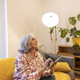 mature woman uses tablet to control light in her smart home - PhotoDune Item for Sale