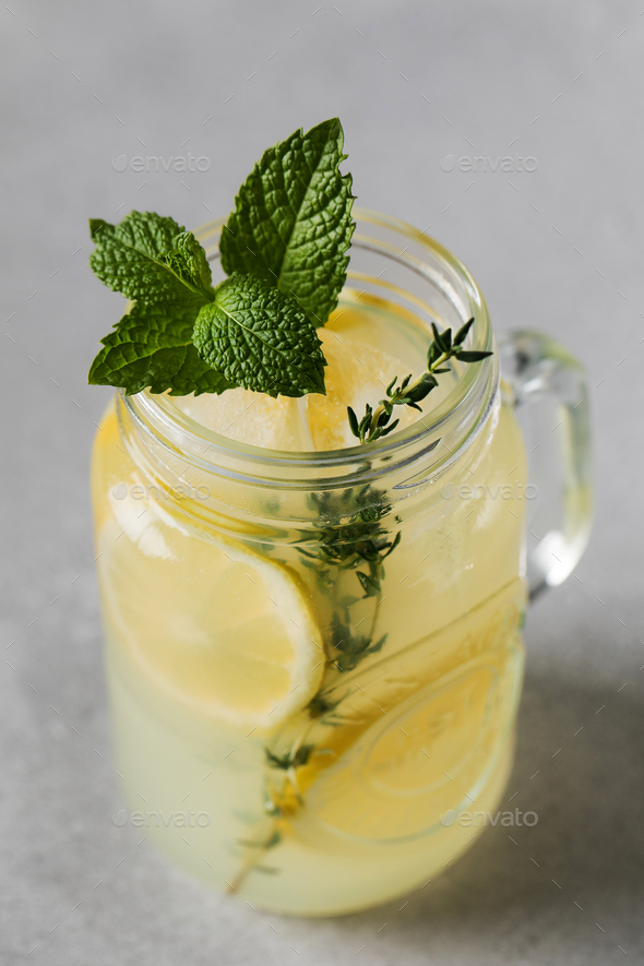 Homemade lemonade with fresh lemon slices and mint leaves in a glass. A summer refreshing drink. - Stock Photo - Images