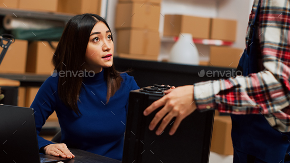 Asian guy organizing boxes with supplies on shelves Stock Photo by