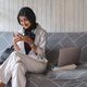 Muslim teen girl checking social media holding smartphone at home - PhotoDune Item for Sale
