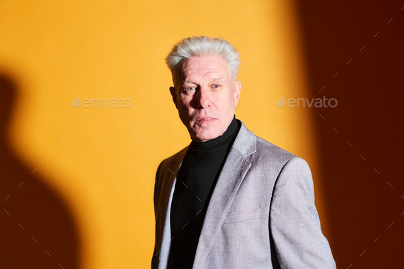 Serious mature businessman in grey blazer and black turtleneck - Stock Photo - Images